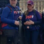 Raynor Winn and Friend in front of the Houses of Parliament, London, at the end of their walk in April